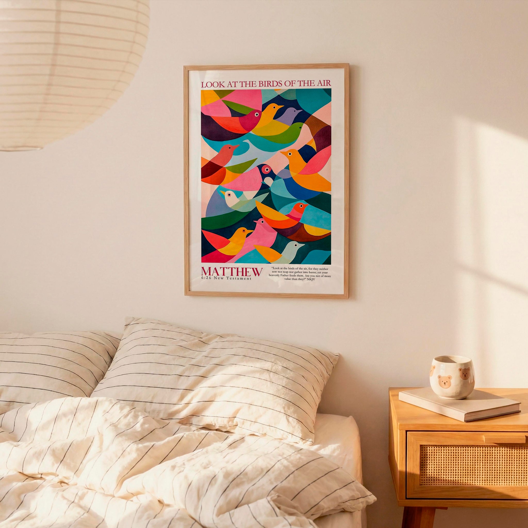 a poster of colorful birds hanging on a wall above a bed with striped pillows.