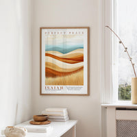 a framed poster of a desert landscape with the text "Perfect Peace" and " Isaiah" below it, hanging on a white wall.