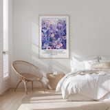 A bedroom with a bed, a woven chair, and a framed poster of a floral design on the wall.