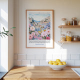 a kitchen scene with a framed poster of a colorful floral landscape hanging on the wall above a wooden countertop with a bowl of lemons.