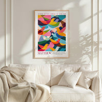 a poster of colorful birds hanging on a wall above a white couch with pillows.