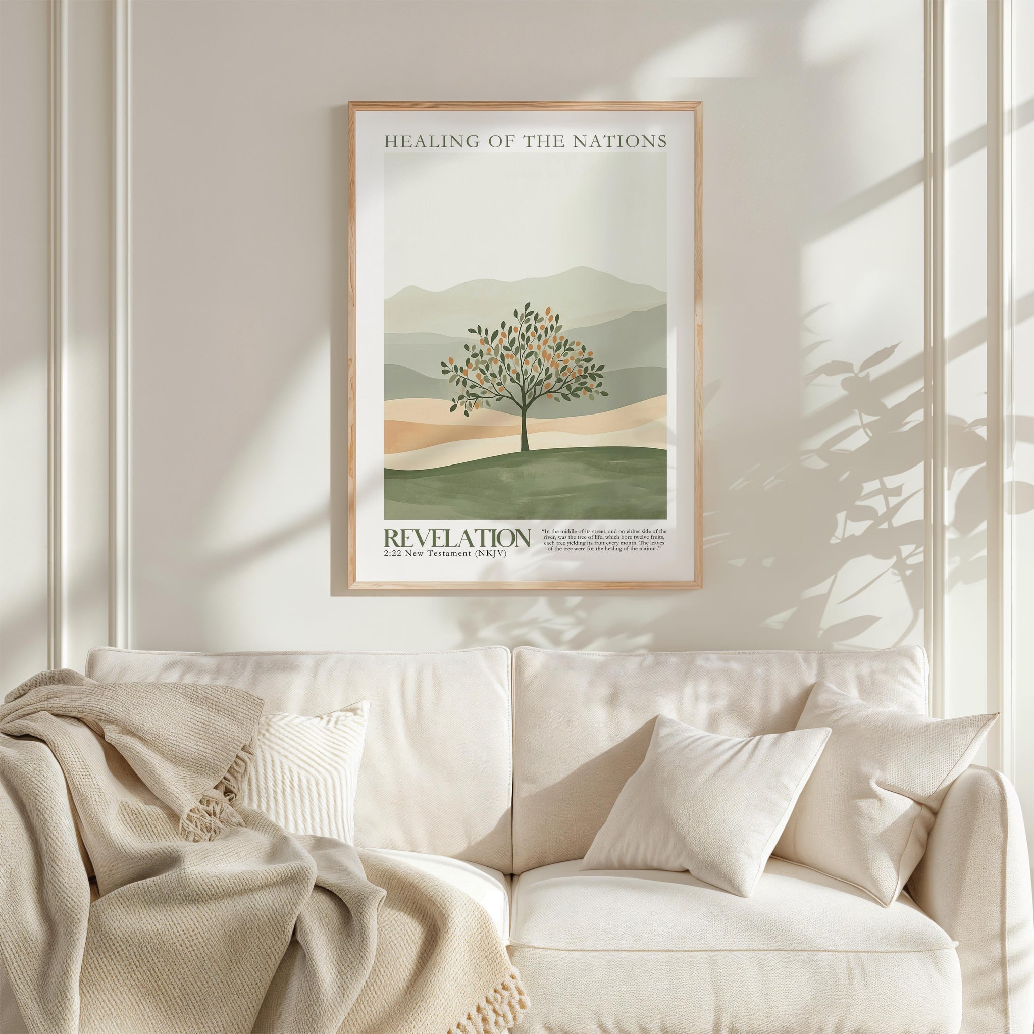 a framed poster of a tree with a landscape in the background, hanging on a wall above a white couch with pillows.