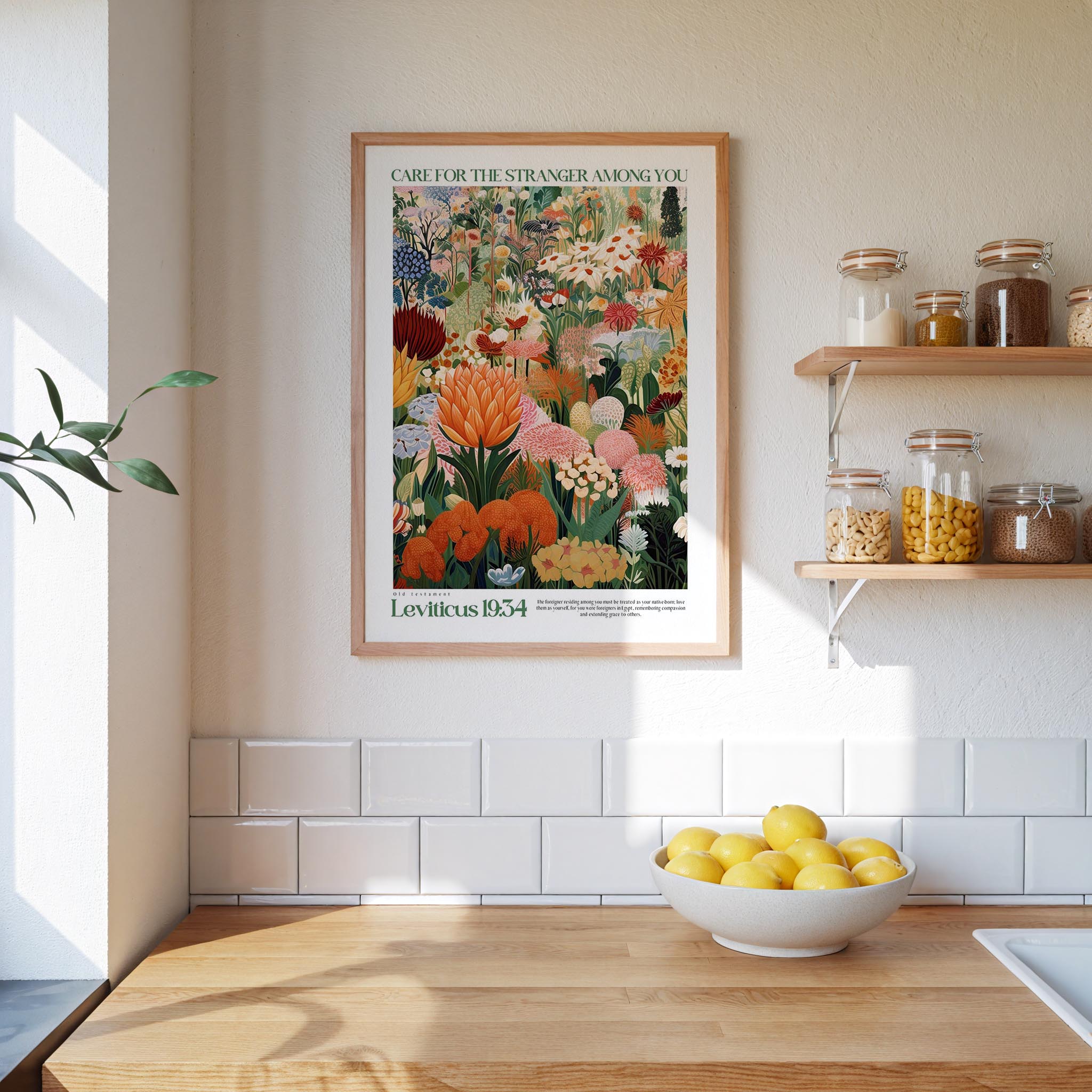 a kitchen scene with a framed poster of a colorful garden hanging on the wall above a wooden countertop. On the countertop, there is a bowl of lemons and a plant.