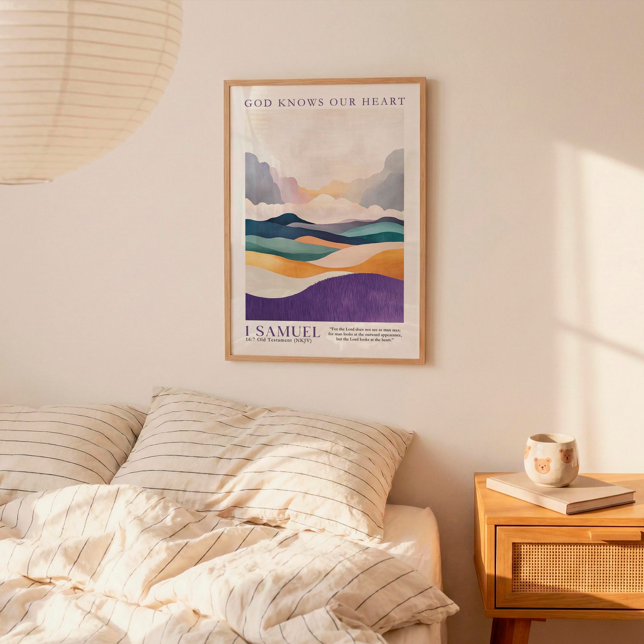 a bedroom setting with a framed poster of a mountain landscape hanging on the wall above a bed with striped bedding.
