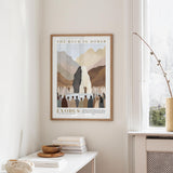 a framed poster of a desert landscape with a group of people gathered around a large rock formation, which appears to be the "Rock in Horeb" in the biblical story of Exodus.