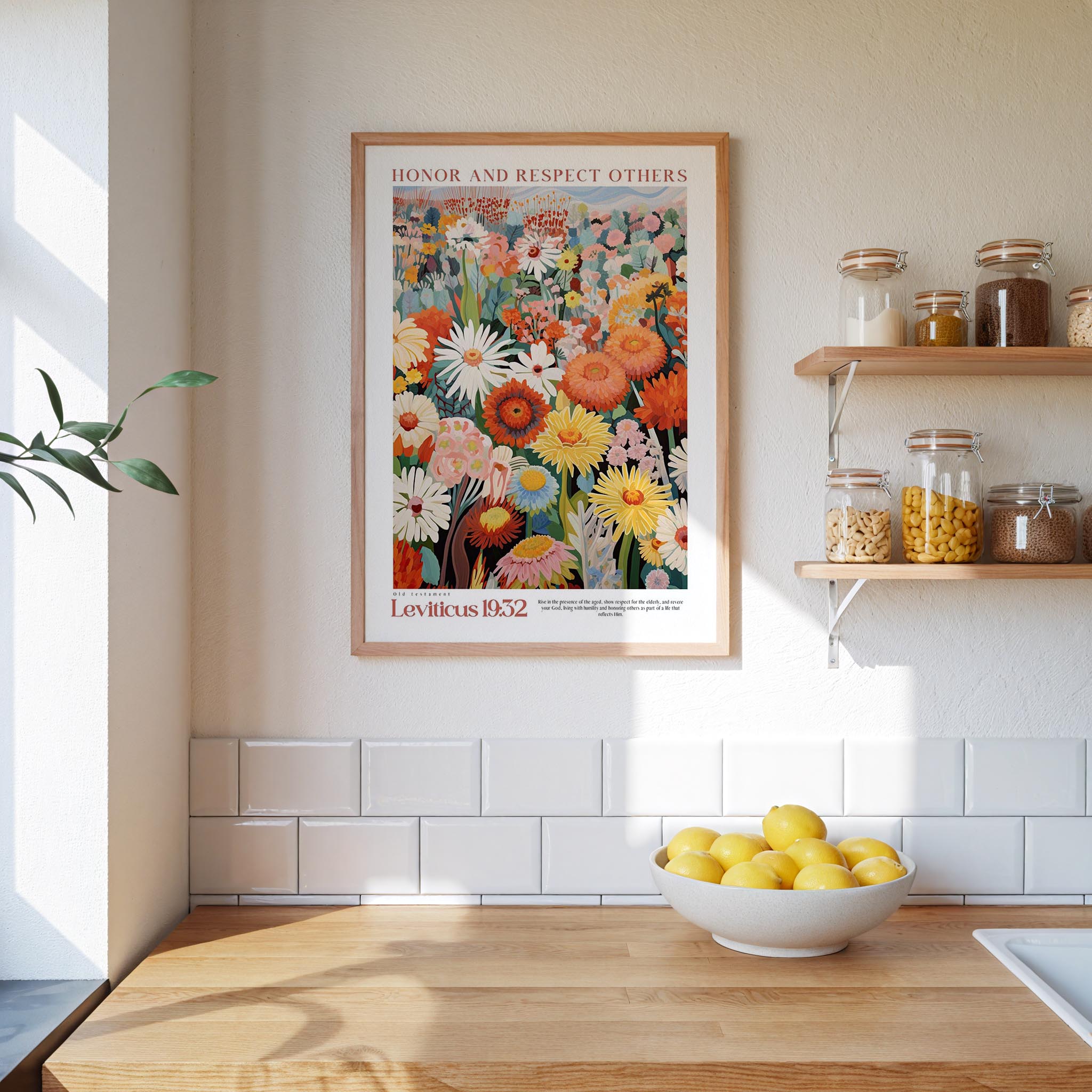 a kitchen scene with a framed poster of a colorful floral arrangement hanging on the wall above a wooden countertop. On the countertop, there is a bowl of lemons and a plant.
