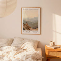 a bedroom scene with a framed poster of a mountain landscape hanging on the wall above a bed with striped bedding.