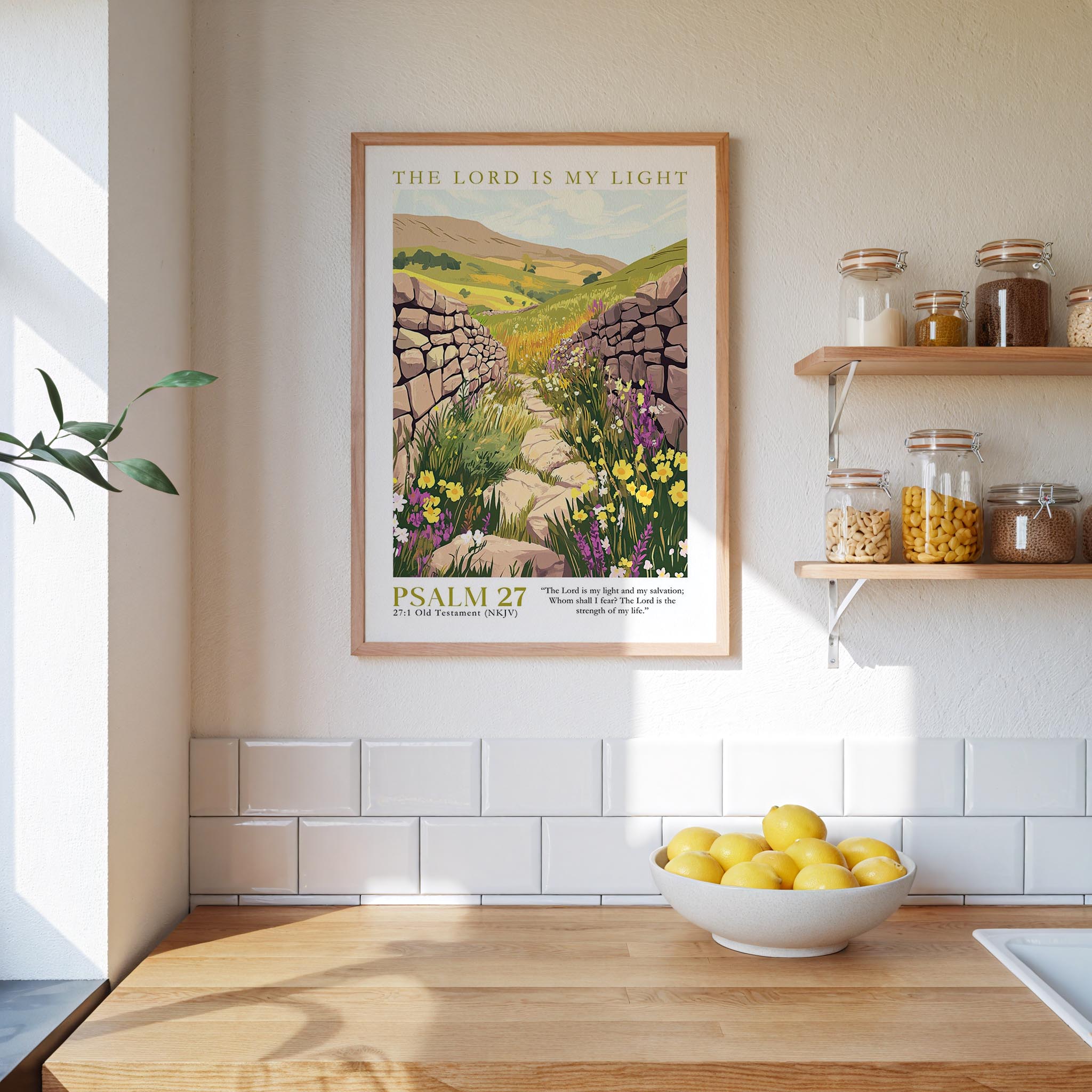a kitchen scene with a framed poster of a stone path leading through a field of flowers, a bowl of lemons, and shelves with jars and bottles.