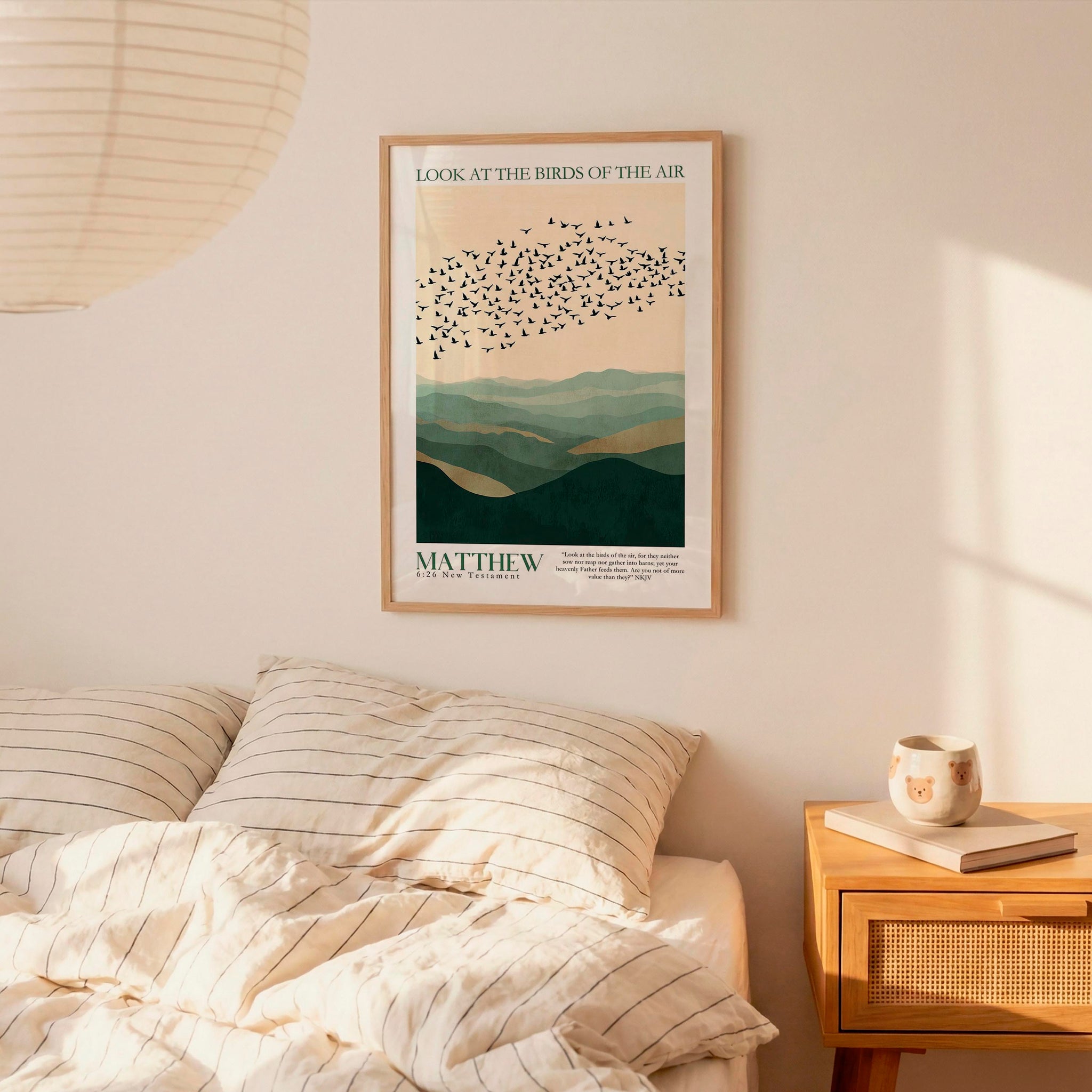 a bedroom setting with a framed poster of a mountain landscape hanging on the wall above a bed with striped bedding.
