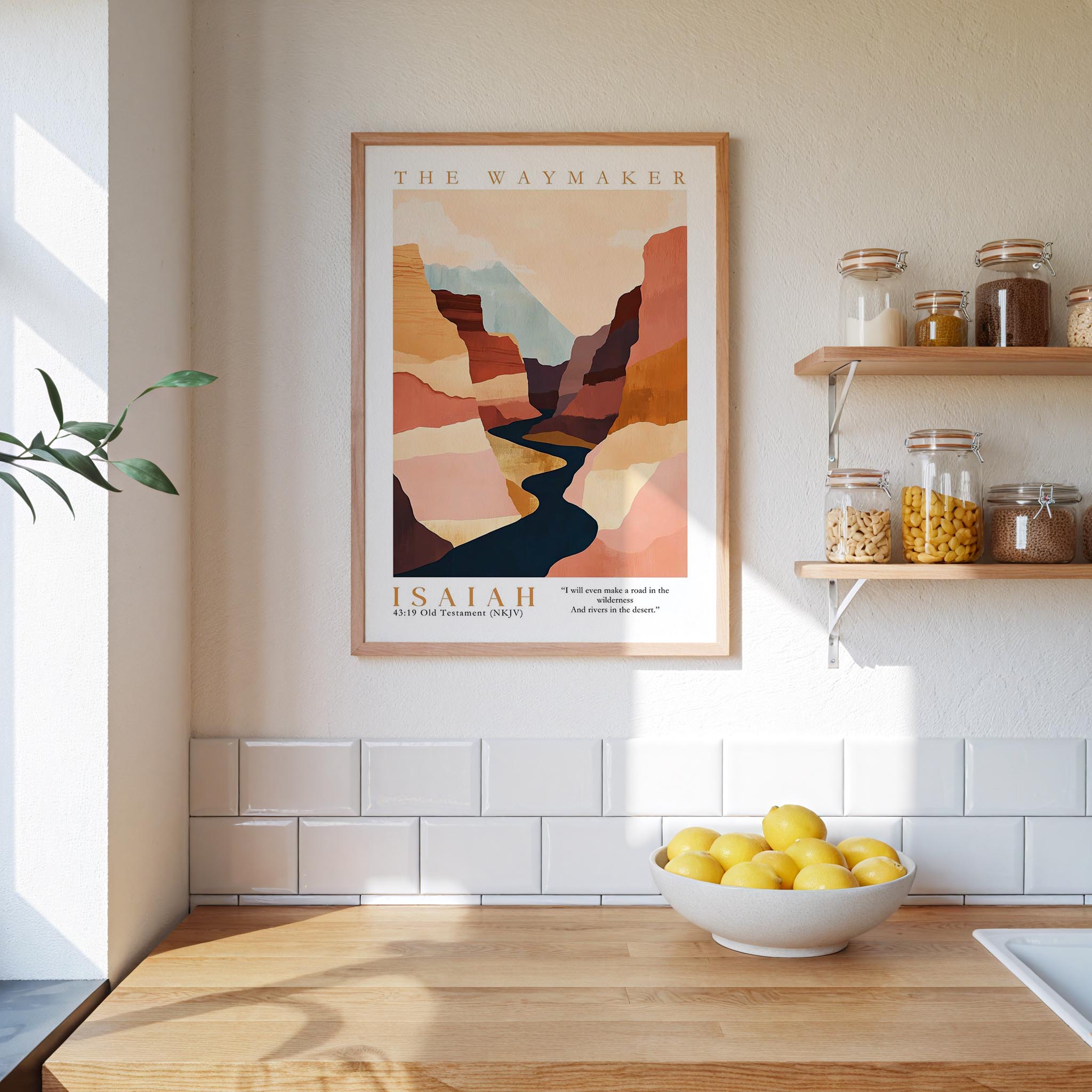 a kitchen counter with a bowl of lemons, a framed poster of a mountain landscape, and a shelf with jars and other kitchen items.