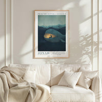 a framed poster of a whale with a light inside, hanging on a wall above a white couch with a blanket draped over it.