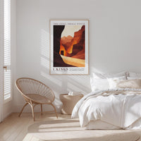 a bedroom with a bed, a woven chair, and a framed poster on the wall.