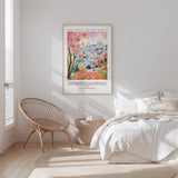 A bedroom with a large bed, a woven chair, and a framed poster of a colorful illustration hanging on the wall.