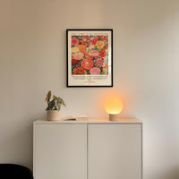 a white cabinet with a potted plant and a lamp on top, set against a white wall.